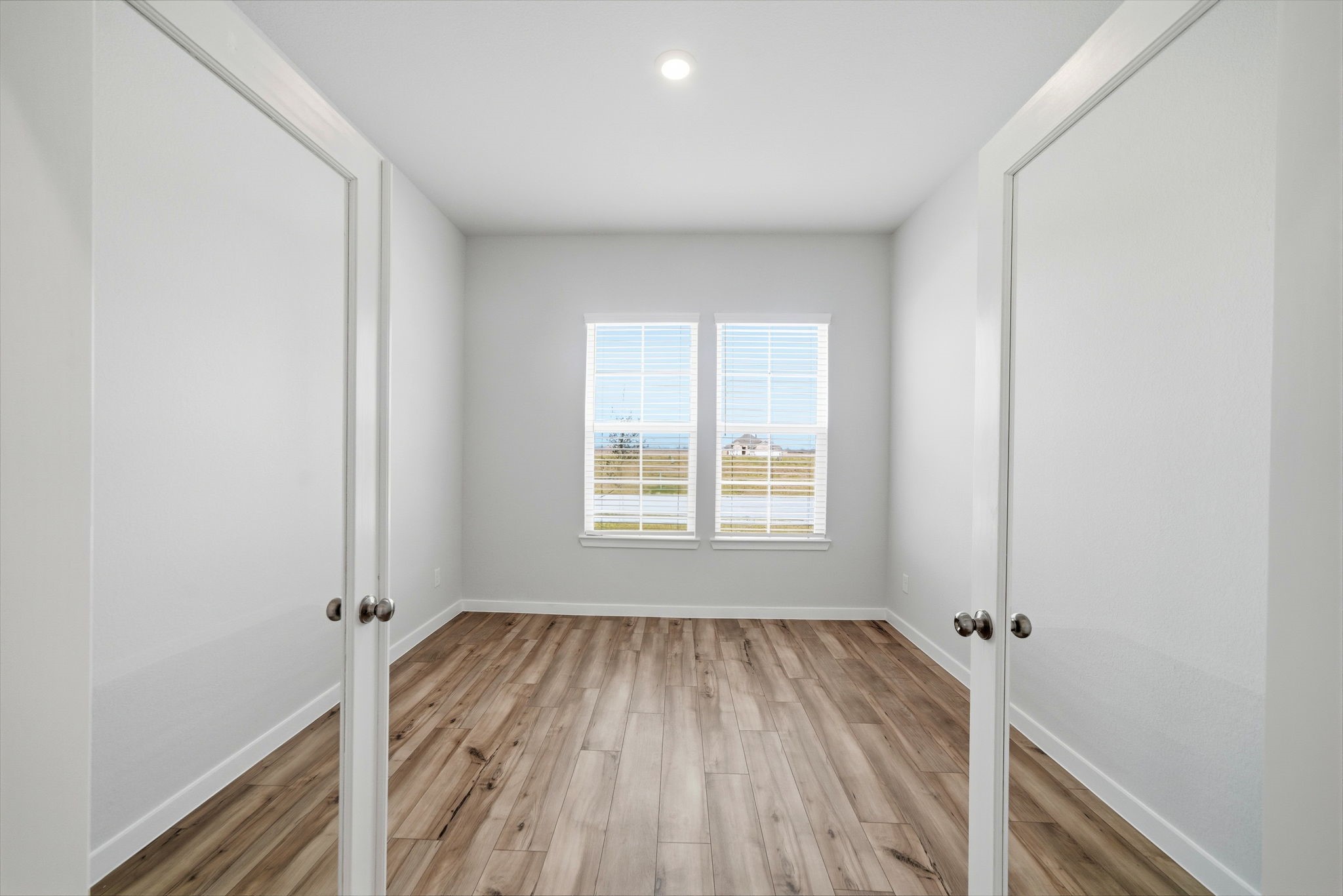 1593 Elm Place Angleton, TX 77515 - Photo 8 of 31 an empty room with wooden floor and windows