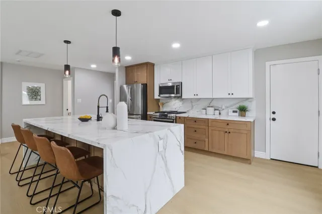 a kitchen with kitchen island a white counter top space cabinets and appliances