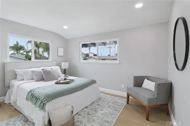 a bedroom with a bed and a lamp on the dresser