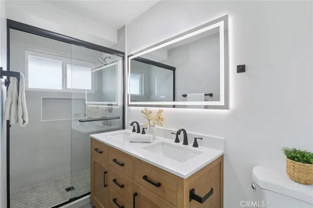 a bathroom with a sink a toilet and shower