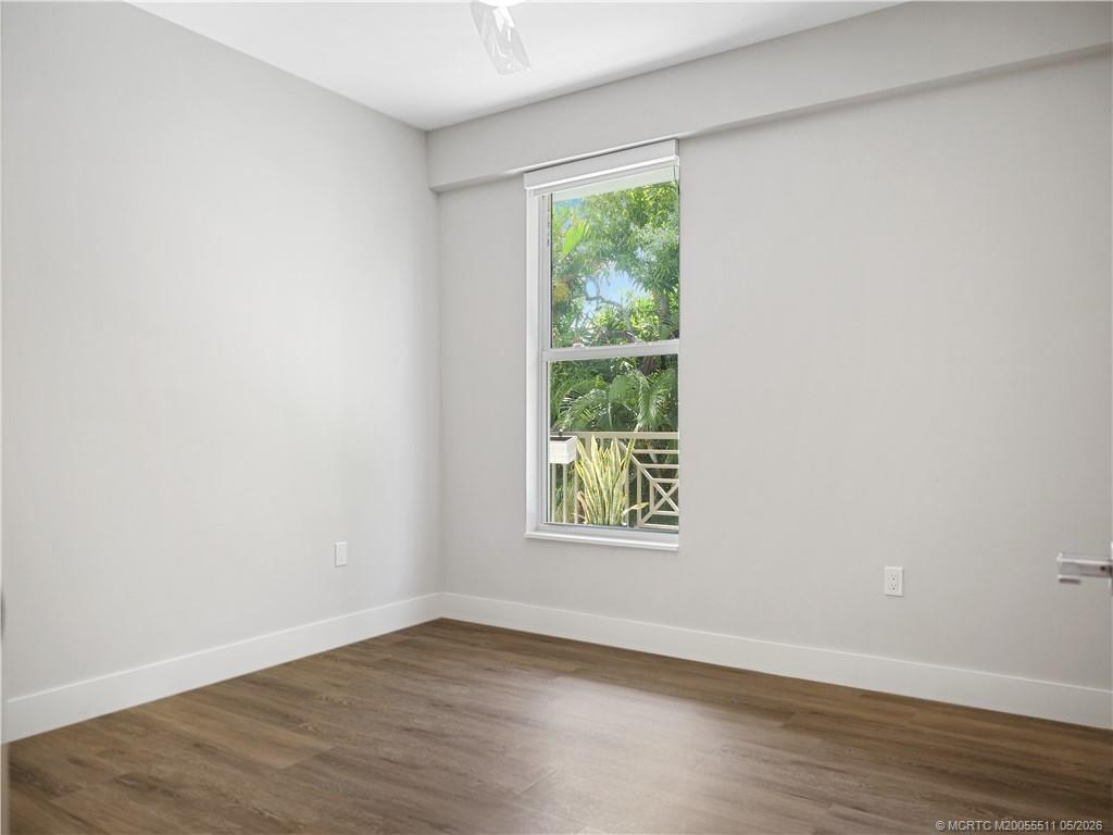 41 Southwest Seminole Street, Unit 208 Stuart, FL 34994 - Photo 31 of 46 an empty room with wooden floor and a window