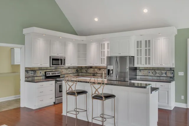 a kitchen with granite countertop a stove sink and refrigerator