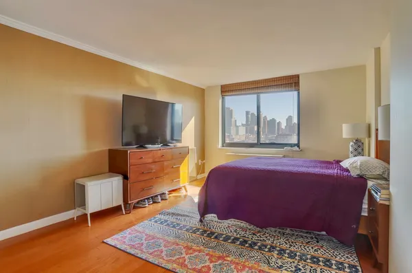 a room with lots of white furniture and a large window