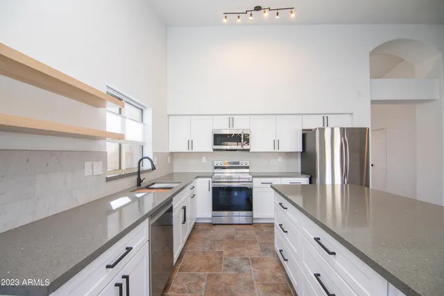 a kitchen with stainless steel appliances granite countertop a sink stove and refrigerator