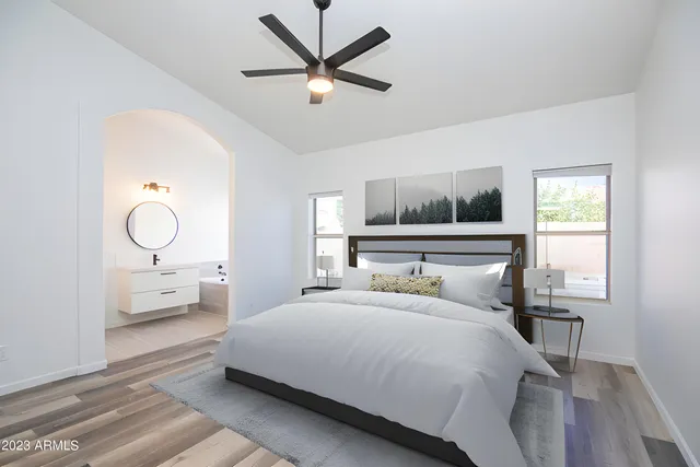 a bedroom with a bed mirror and a window