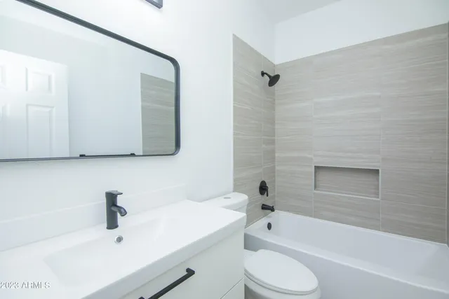 a bathroom with a bathtub shower sink vanity and toilet