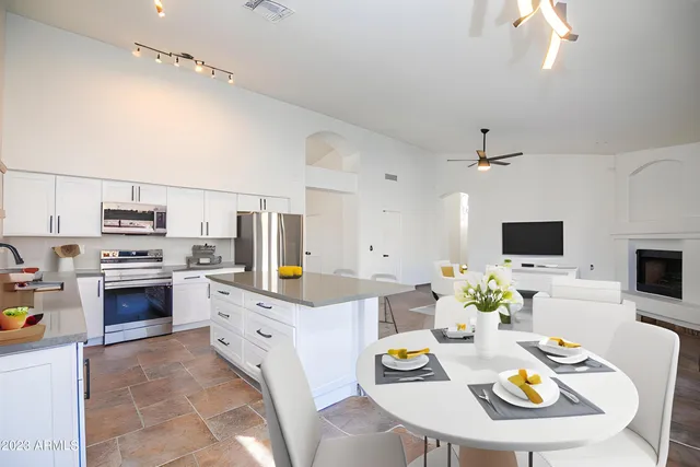 a kitchen with stainless steel appliances kitchen island granite countertop a sink and white cabinets