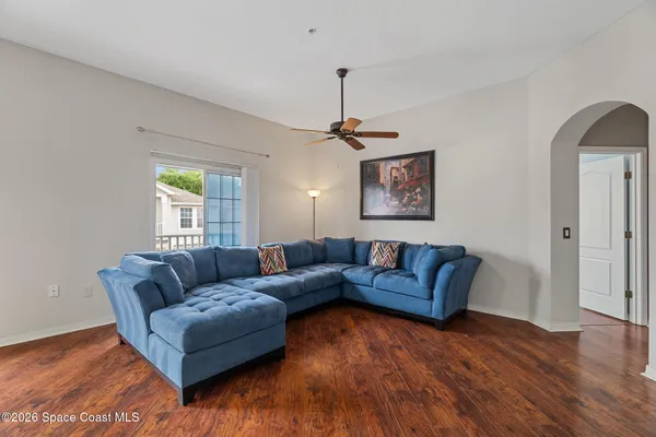 a living room with furniture and a wooden floor