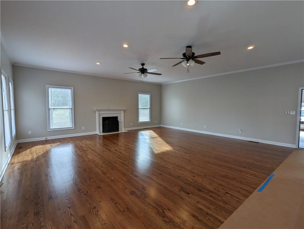 2619 Hinson Road Monroe, NC 28112 - Photo 16 of 39 an empty room with wooden floor ceiling fan and windows
