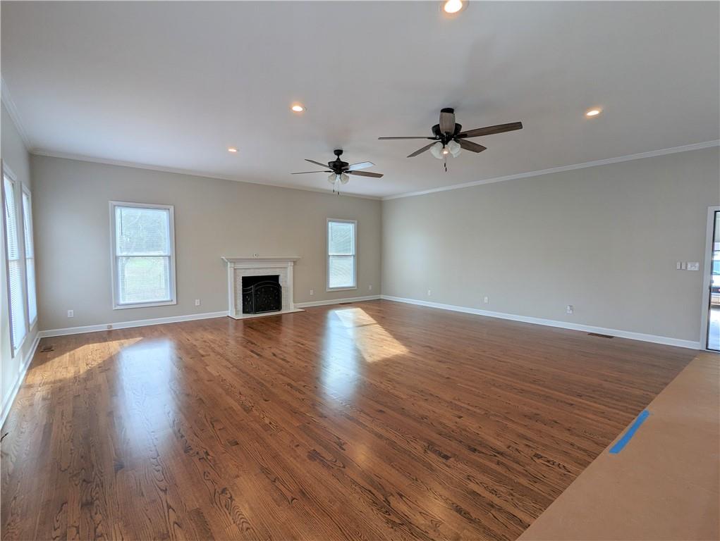 2619 Hinson Road Monroe, NC 28112 - Photo 17 of 39 an empty room with wooden floor ceiling fan and windows