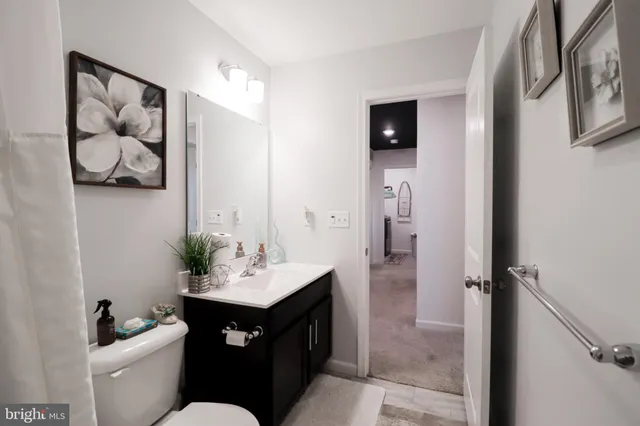 a bathroom with a sink vanity mirror and toilet