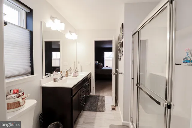 a en suite bathroom with a sink double vanity and a mirror