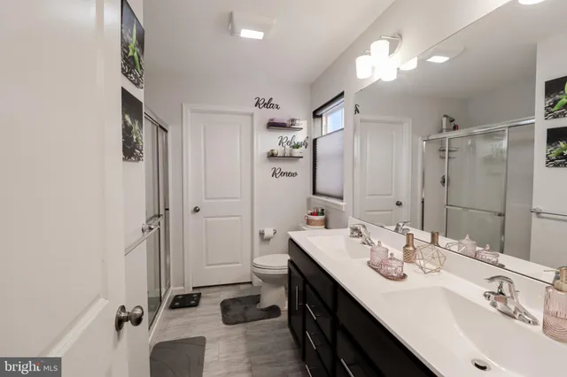 a bathroom with a double vanity sink mirror and shower