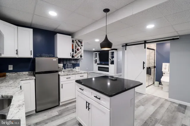 a kitchen with stainless steel appliances granite countertop a sink a stove a refrigerator and island