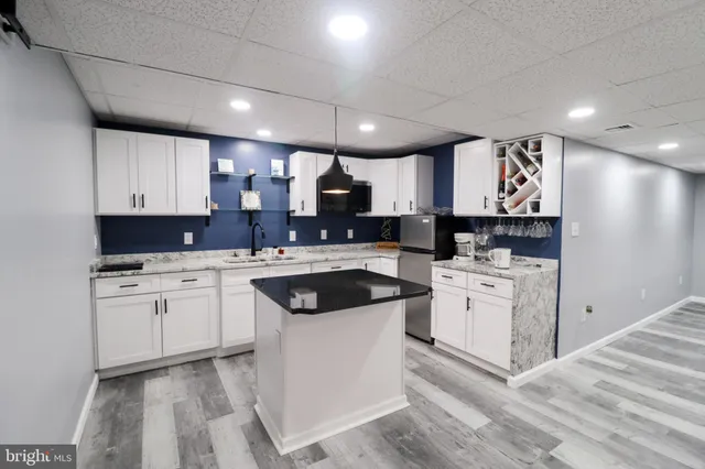 a kitchen with white cabinets sink and stainless steel appliances