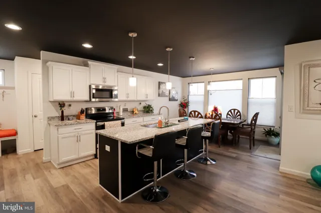 a kitchen with kitchen island granite countertop lots of counter top space and stainless steel appliances