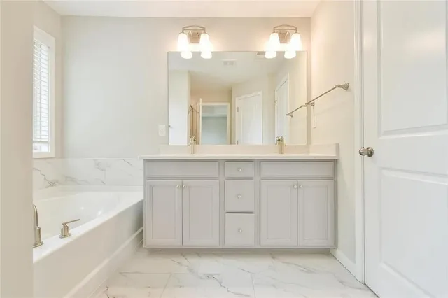a spacious bathroom with a bathtub sink and mirror