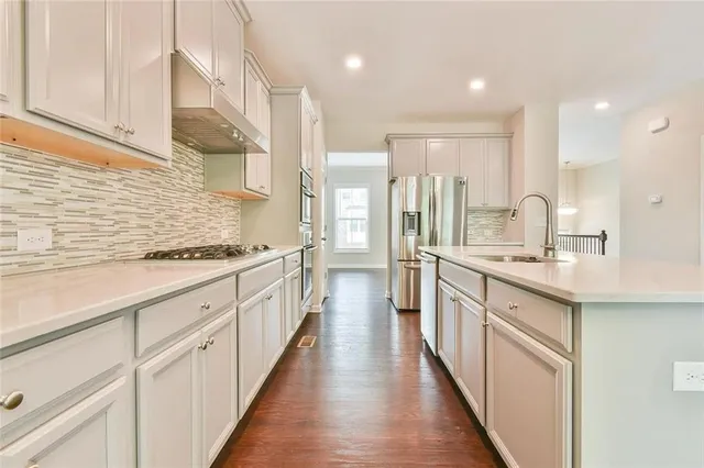 a large kitchen with stainless steel appliances lots of counter space and a sink