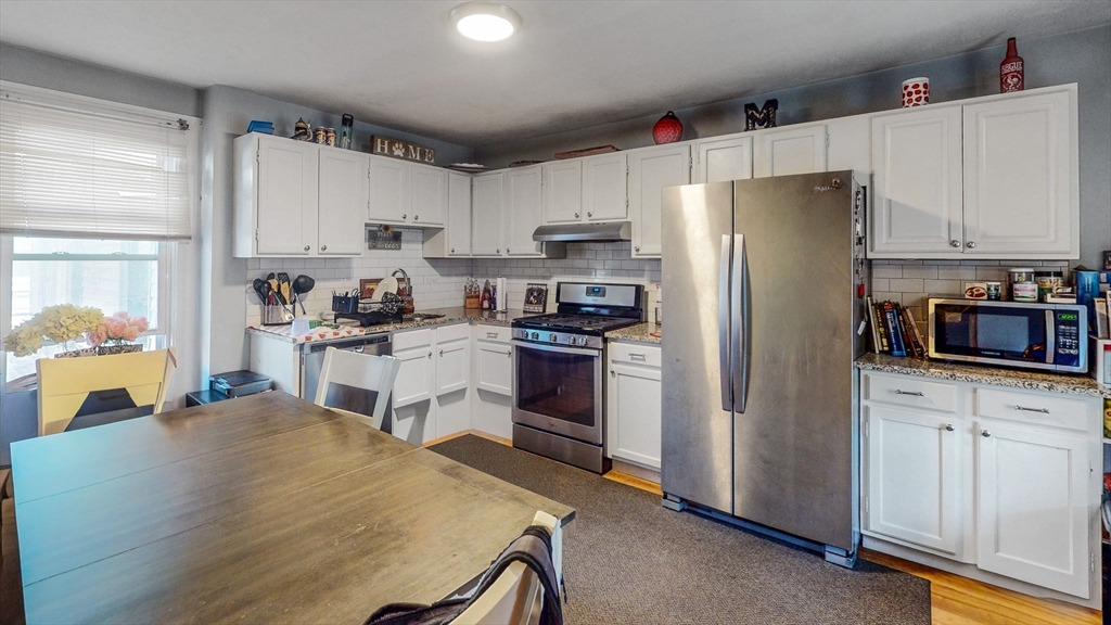 17-19 Crafts Street Newton, MA 02458 - Photo 2 of 24 a kitchen with white cabinets and stainless steel appliances