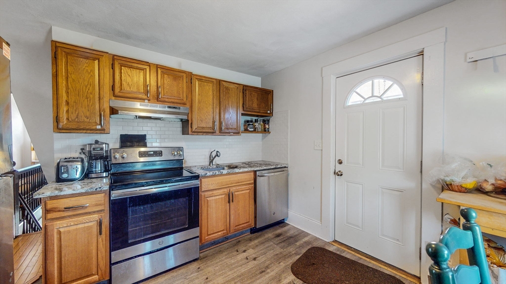 17-19 Crafts Street Newton, MA 02458 - Photo 9 of 24 a kitchen with stainless steel appliances granite countertop a stove a sink and a refrigerator