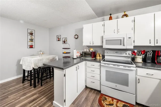 a kitchen with granite countertop a sink appliances cabinets and counter space