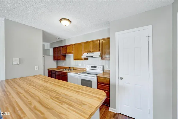 a large kitchen with a stove a sink dishwasher and a refrigerator