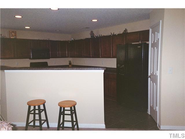 5955 Ricker Road Raleigh, NC 27610 - Photo 11 of 20 a kitchen with cabinets and a refrigerator