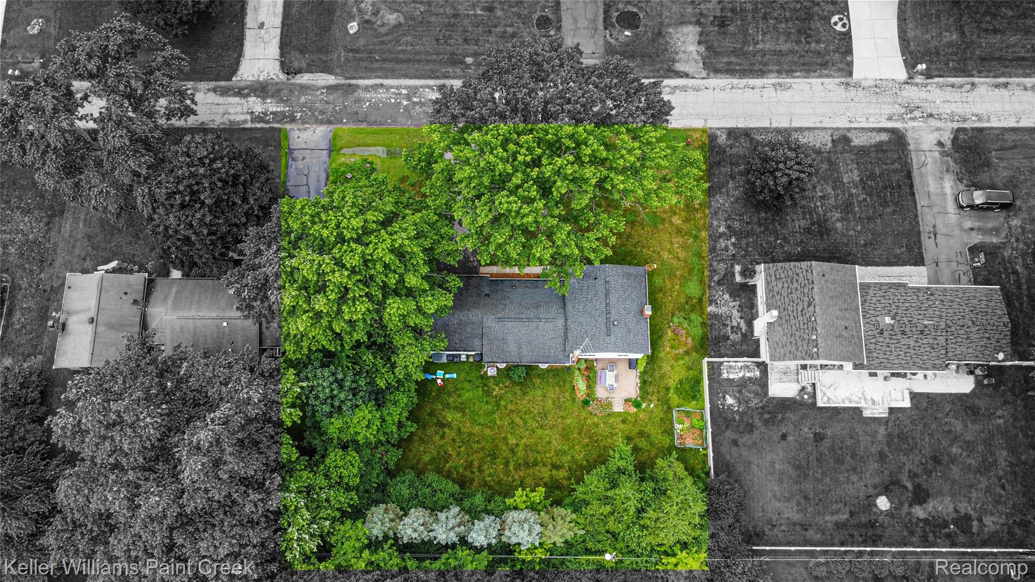 7093 Stonebrook Road West Bloomfield, MI 48322 - Photo 62 of 64 Property featuring a green lawn and mature trees, bordered by a hedge