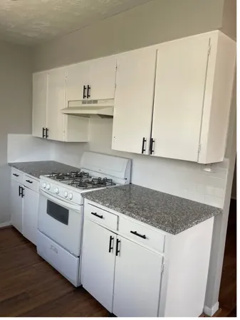a white kitchen with sink and microwave