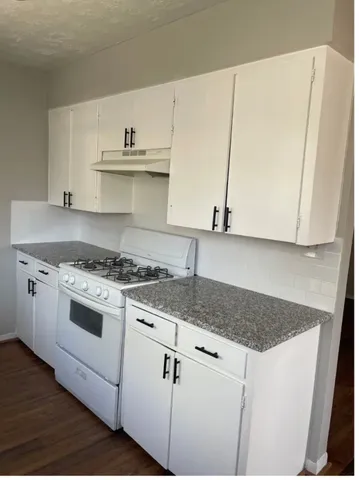 a white kitchen with sink and microwave