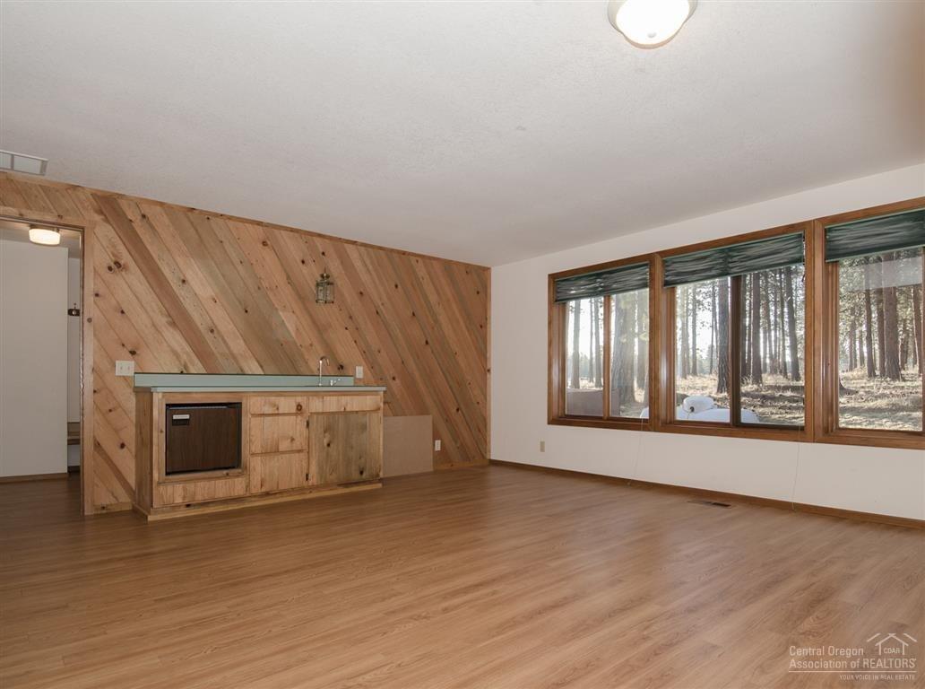 20903 Knott Road Bend, OR 97702 - Photo 13 of 23 a view of an empty room with a fireplace and wooden floor