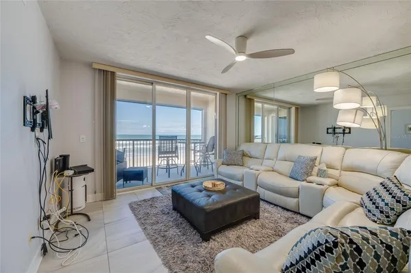 a living room with furniture kitchen view and a chandelier