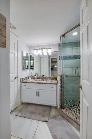 a kitchen with granite countertop white cabinets and stainless steel appliances