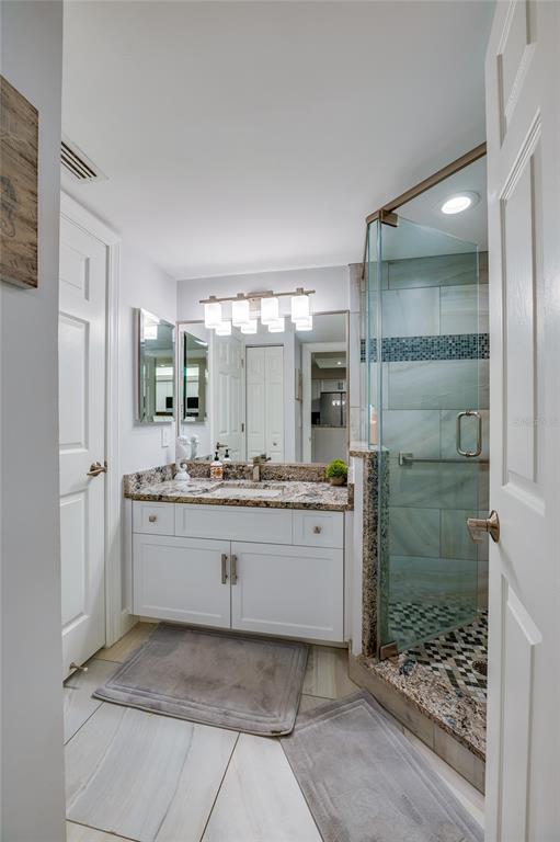 4575 South Atlantic Avenue, Unit 6304 Ponce Inlet, FL 32127 - Photo 29 of 37 a bathroom with a granite countertop sink mirror and shower