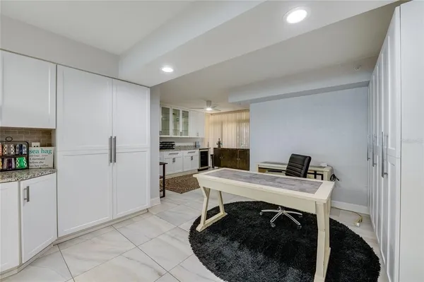 a kitchen with a table chairs refrigerator and cabinets