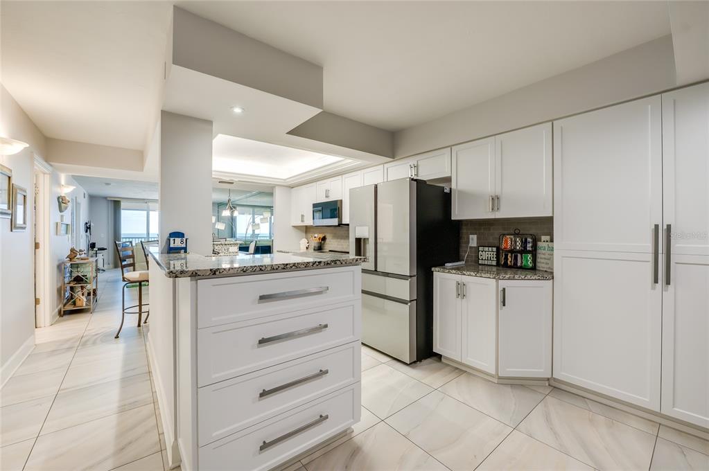 4575 South Atlantic Avenue, Unit 6304 Ponce Inlet, FL 32127 - Photo 7 of 37 a kitchen with white cabinets and stainless steel appliances