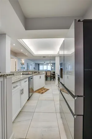 a kitchen with stainless steel appliances granite countertop a stove top oven a sink a dining table and chairs