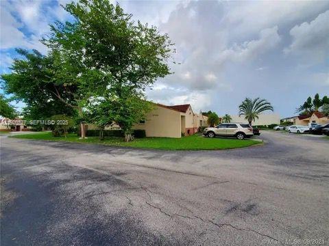 14927 Southwest 89th Street, Unit 14927 Miami, FL 33196 - Photo 11 of 12 a house with trees in front of it