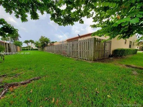 14927 Southwest 89th Street, Unit 14927 Miami, FL 33196 - Photo 12 of 12 a view of a backyard with plants and large trees