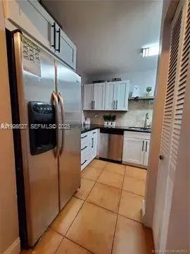 a kitchen with stainless steel appliances granite countertop a refrigerator a stove and a sink with wooden floor