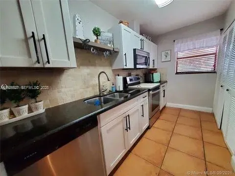a kitchen with stainless steel appliances a sink stove and cabinets