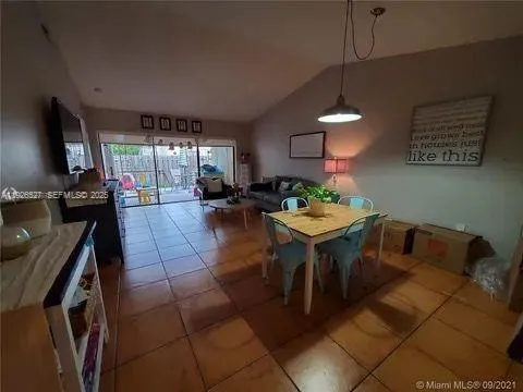 a living room with furniture a flat screen tv and a dining table with a kitchen island