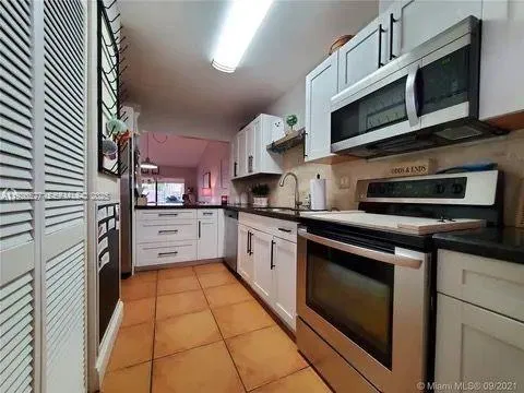a kitchen with stainless steel appliances granite countertop a stove microwave and cabinets
