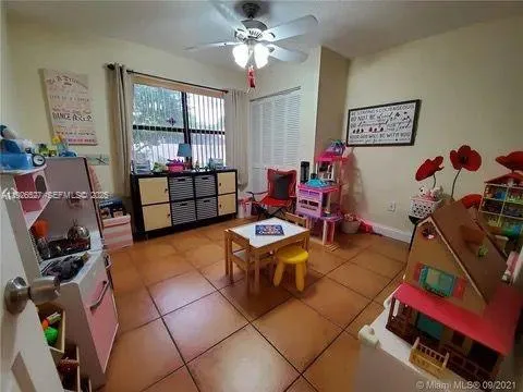 a living room with furniture a window and gym equipment