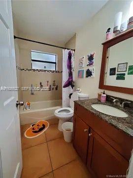 14927 Southwest 89th Street, Unit 14927 Miami, FL 33196 - Photo 10 of 12 a bathroom with a granite countertop sink mirror vanity and toilet