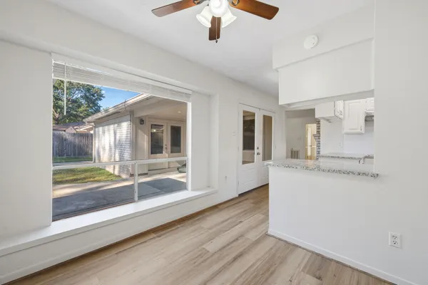 a view of a kitchen with wooden floor and a window