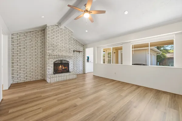 a view of an empty room with a fireplace and a window