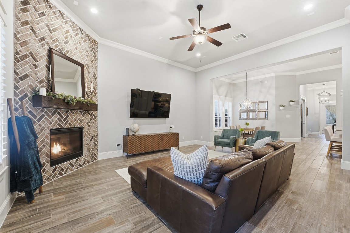 2172 Rope Maker Road Conroe, TX 77384 - Photo 18 of 50 This spacious Family Room features a cozy brick fireplace, modern ceiling fan, and stylish flooring. There are a few ways you can position your furniture and have large spaces for your tv and entertainment area as well. It opens to a dining area with ample natural light, creating a warm, inviting atmosphere perfect for relaxation.