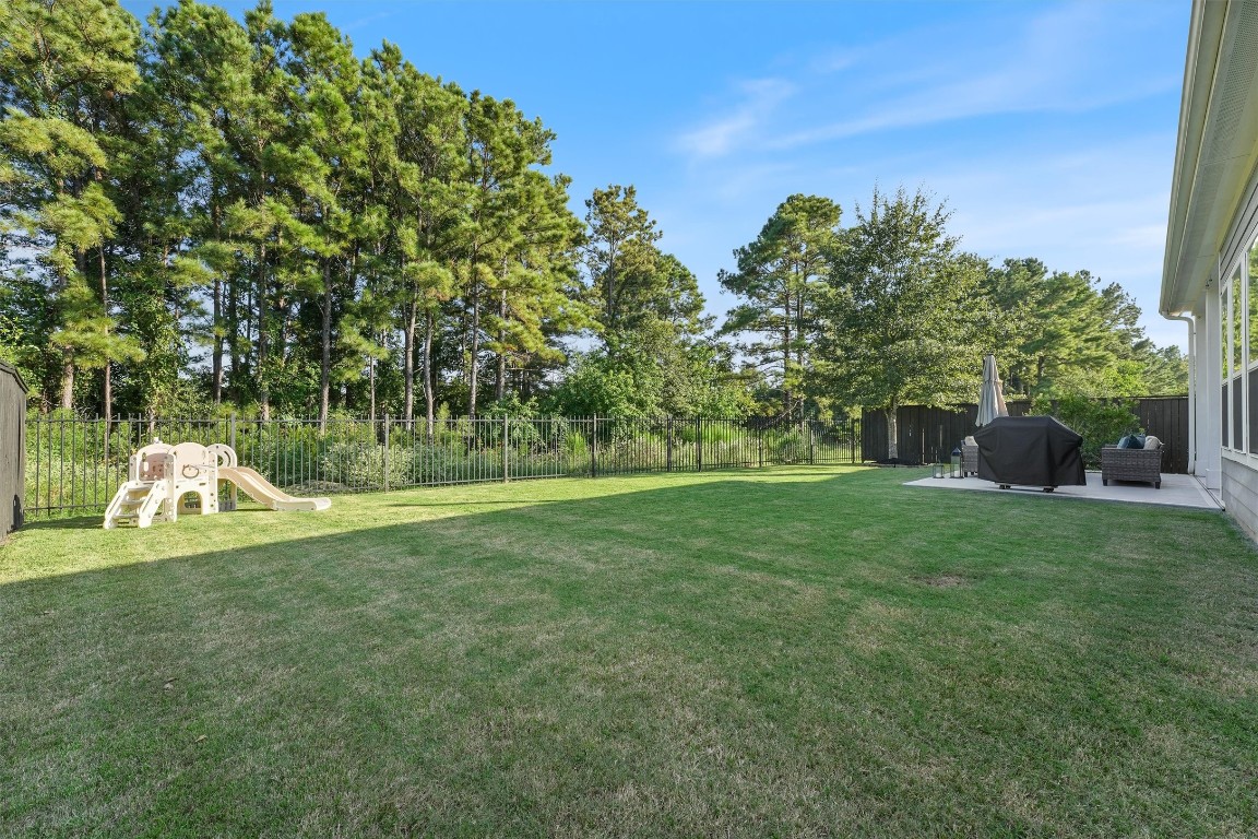 2172 Rope Maker Road Conroe, TX 77384 - Photo 37 of 50 Spacious backyard with lush grassy space with room to play or anything you can imagine. Surrounded by trees in the nature reserve creating the perfect place to enjoy the outdoors.