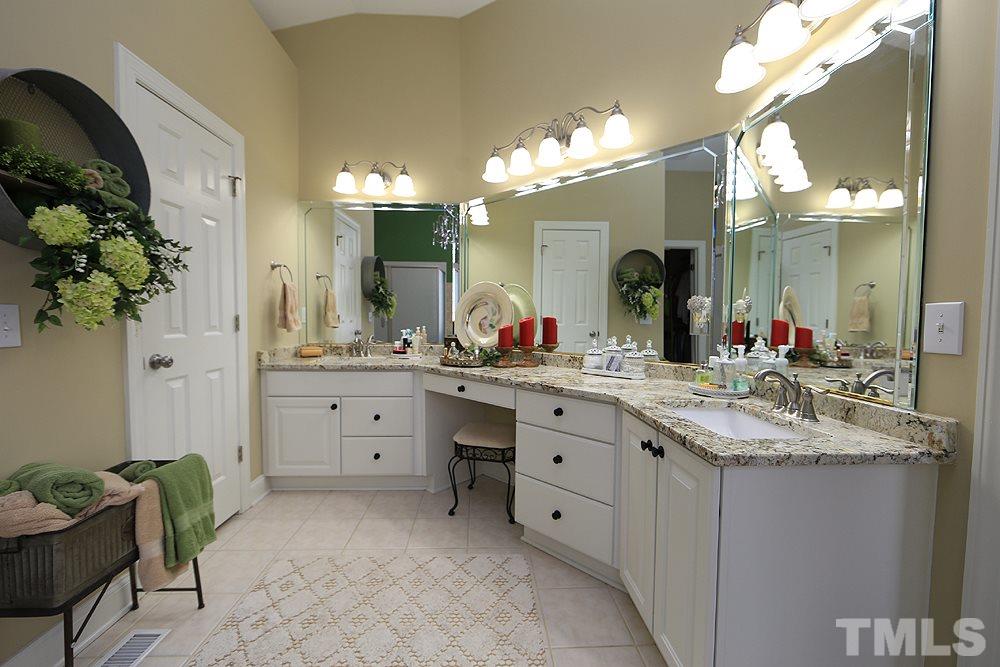521 Competition Road Raleigh, NC 27603 - Photo 11 of 25 Master Bath features double vanities and sitting area. Large master bath that has new granite countertops, fixtures, new marble soaking tub, new shower surround and granite/tile with inset.